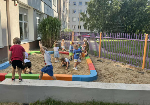 Zdjęcie przedstawia dzieci podczas zabaw w piaskownicy