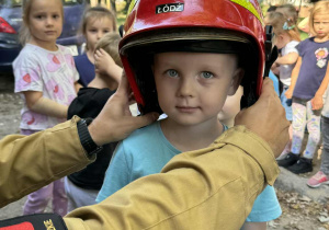 Zdjęcie przedstawia dzieci podczas spotkania ze strażakami