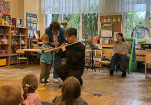 Zdjęcie przedstawia dzieci podczas koncertu muzycznego w przedszkolu