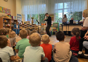 Zdjęcie przedstawia dzieci podczas koncertu muzycznego w przedszkolu