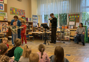 Zdjęcie przedstawia dzieci podczas koncertu muzycznego w przedszkolu