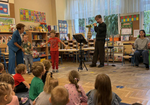 Zdjęcie przedstawia dzieci podczas koncertu muzycznego w przedszkolu