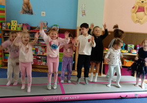 Zdjęcie przedstawia dzieci bawiące się na macie do akrobatyki