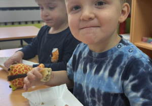 Zdjęcie przedstawia dzieci zajadające różne smakołyki