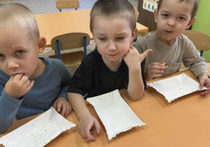 Zdjęcie przedstawia dzieci zajadające różne smakołyki