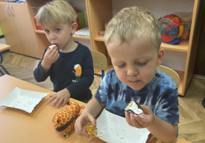 Zdjęcie przedstawia dzieci zajadające różne smakołyki
