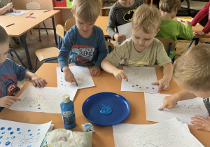 Zdjęcie przedstawia dzieci podczas malowania palcami