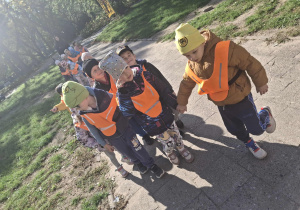 Zdjęcie przedstawia dzieci podczas spaceru w parku