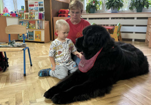 Zdjęcie przedstawia dzieci podczas zabaw z psem