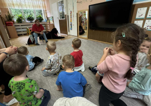 Zdjęcie przedstawia dzieci podczas zabaw z psem