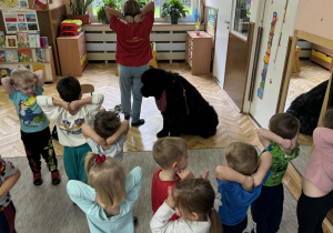 Zdjęcie przedstawia dzieci podczas zabaw z psem