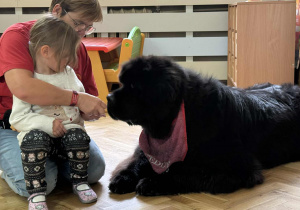 Zdjęcie przedstawia dzieci podczas zabaw z psem