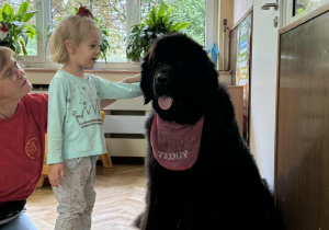 Zdjęcie przedstawia dzieci podczas zabaw z psem