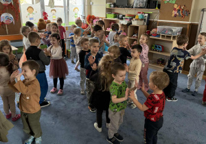 Zdjęcie przedstawia dzieci podczas koncertu muzycznego w przedszkolu