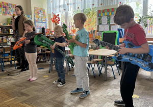 Zdjęcie przedstawia dzieci podczas koncertu muzycznego w przedszkolu