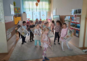 Zdjęcie przedstawia dzieci podczas zabaw z gazetami