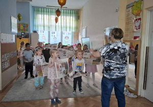 Zdjęcie przedstawia dzieci podczas zabaw z gazetami