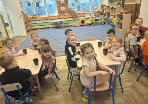 Zdjęcie przedstawia dzieci podczas robienia soku z owoców