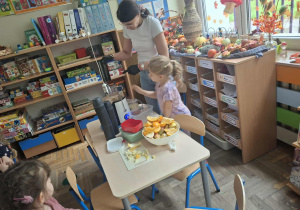 Zdjęcie przedstawia dzieci podczas robienia soku z owoców