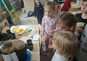 Zdjęcie przedstawia dzieci podczas robienia soku z owoców