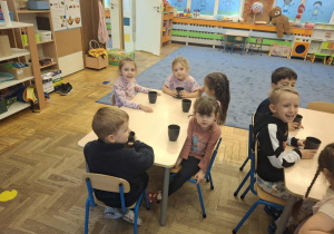 Zdjęcie przedstawia dzieci podczas robienia soku z owoców