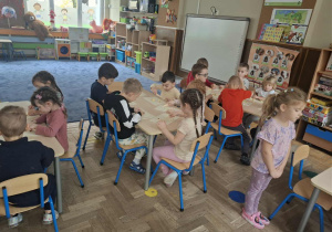 Zdjęcie przedstawia dzieci podczas robienia soku z owoców