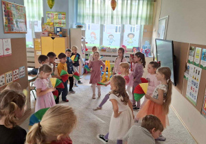 Zdjęcie przedstawia dzieci podczas zajęć muzyczno- ruchowych