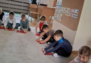 Zdjęcie przedstawia dzieci podczas zajęć muzyczno- ruchowych