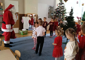Zdjęcie przedstawia dzieci podczas spotkania z Mikołajem