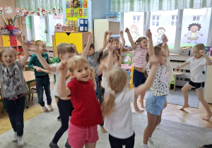 Zdjęcie przedstawia dzieci podczas ćwiczeń ruchowych