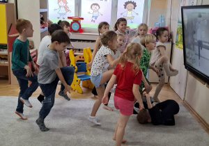 Zdjęcie przedstawia dzieci podczas ćwiczeń ruchowych