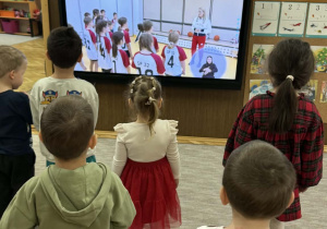 Zdjęcie przedstawia dzieci podczas ćwiczeń ruchowych