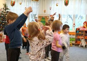 Zdjęcie przedstawia dzieci podczas ćwiczeń ruchowych