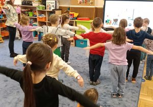 Zdjęcie przedstawia dzieci podczas ćwiczeń ruchowych