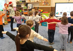 Zdjęcie przedstawia dzieci podczas ćwiczeń ruchowych