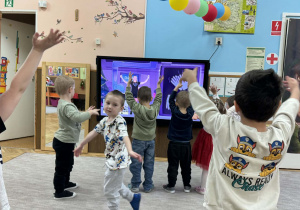 Zdjęcie przedstawia dzieci podczas ćwiczeń ruchowych