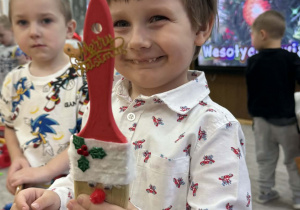 Zdjęcie przedstawia dzieci z wykonanym Mikołajem z pędzla