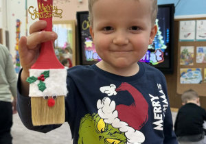 Zdjęcie przedstawia dzieci z wykonanym Mikołajem z pędzla