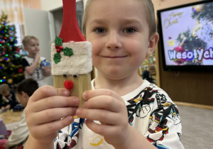 Zdjęcie przedstawia dzieci z wykonanym Mikołajem z pędzla