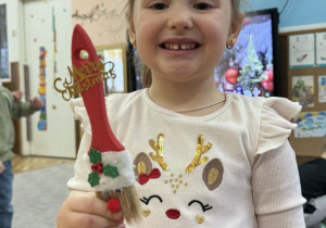 Zdjęcie przedstawia dzieci z wykonanym Mikołajem z pędzla