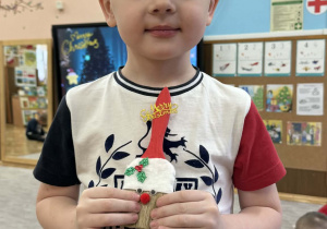 Zdjęcie przedstawia dzieci z wykonanym Mikołajem z pędzla