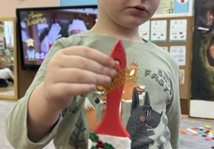 Zdjęcie przedstawia dzieci z wykonanym Mikołajem z pędzla