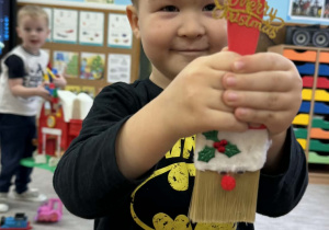 Zdjęcie przedstawia dzieci z wykonanym Mikołajem z pędzla