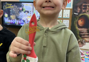 Zdjęcie przedstawia dzieci z wykonanym Mikołajem z pędzla