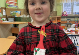 Zdjęcie przedstawia dzieci z wykonanym Mikołajem z pędzla