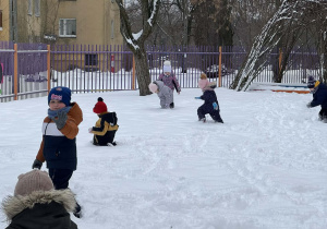 Zdjęcie przedstawia dzieci podczas zabaw na śniegu