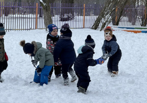 Zdjęcie przedstawia dzieci podczas zabaw na śniegu