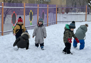 Zdjęcie przedstawia dzieci podczas zabaw na śniegu