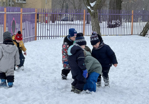 Zdjęcie przedstawia dzieci podczas zabaw na śniegu