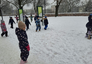Zdjęcie przedstawia dzieci podczas zabaw na śniegu